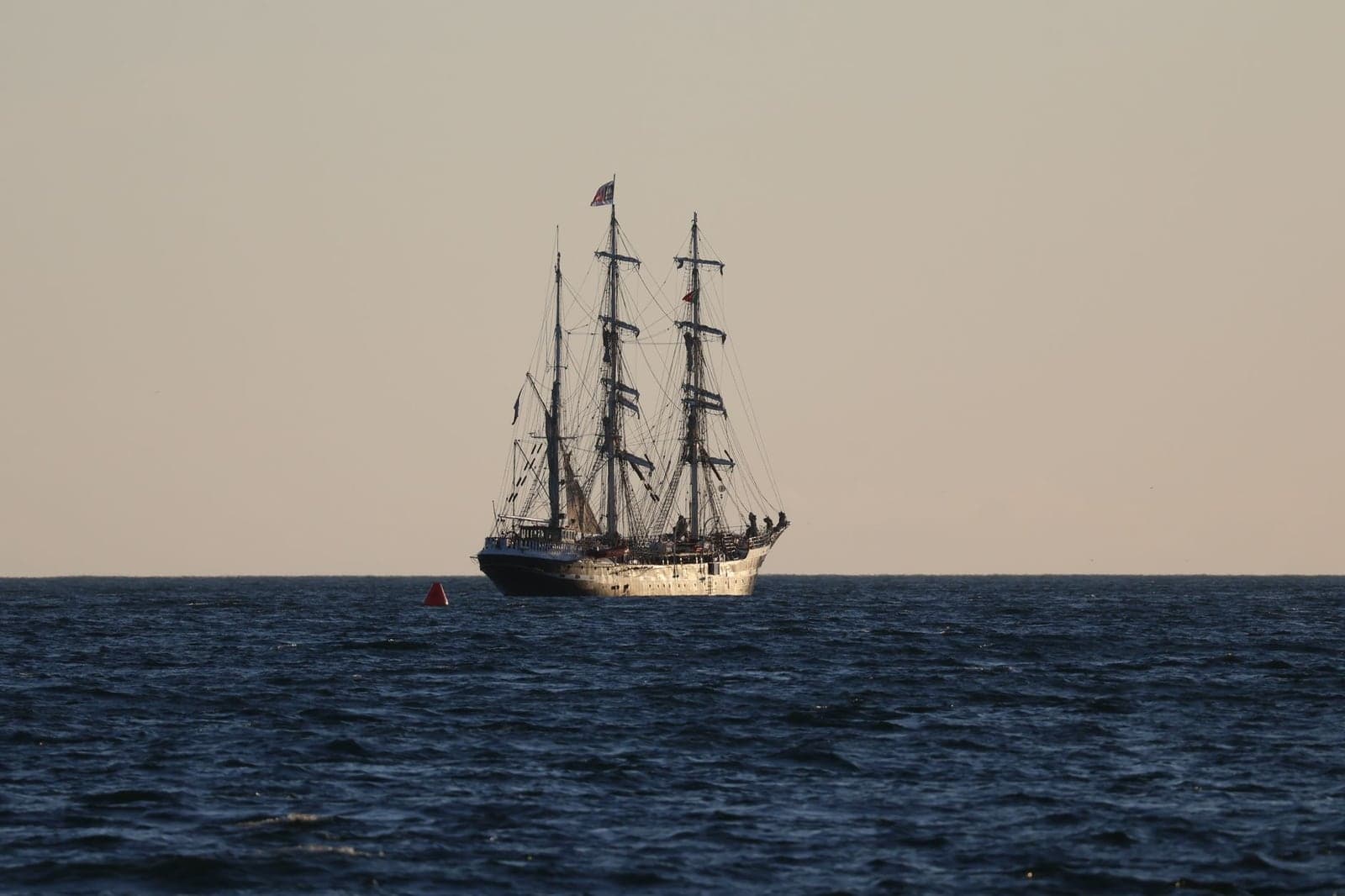 A tall sailing ship on a calm sea under a clear sky, a strong still to animate